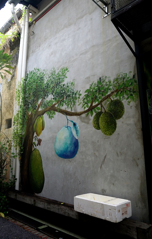 Hmmm, street art - a durian tree with some magical blue fruit? Looks like a pomelo to me. Ipoh is well-known for their pomelos... why blue, I wonder... Edit: Silly me - didn’t notice, it has different Malaysian fruits on the one tree! Huge jackfruit on the trunk (that’s how jackfruits grow...), a bunch of much smaller reddish rambutans above (rambutans = the very sweet hairy fruit), papayas above that, in a cluster of three, durians to the right, with thorns, also a bunch of three!