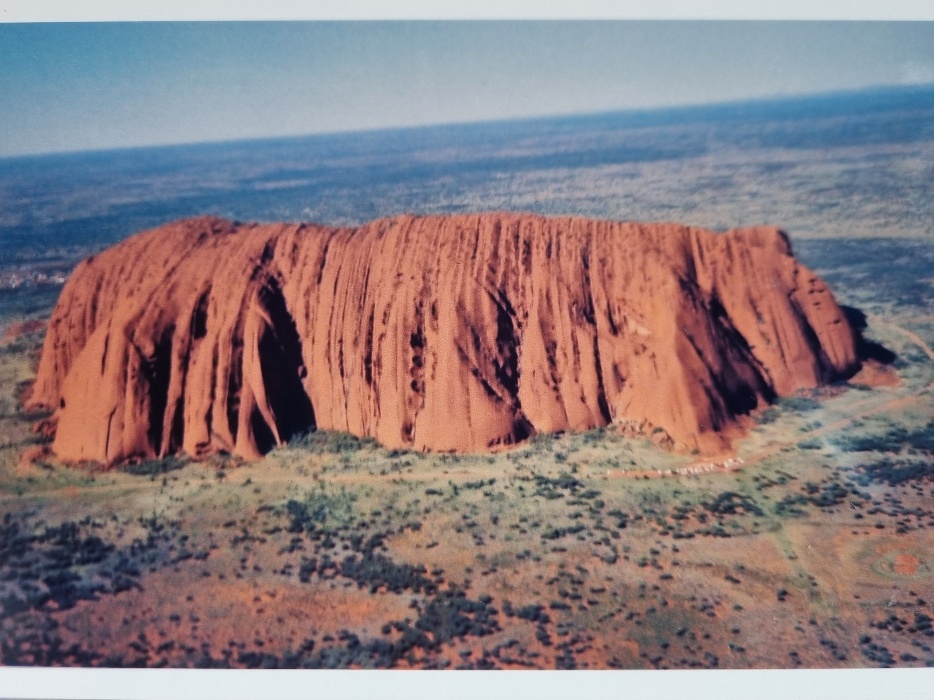 I distinctly remember the first time I saw this monolith. I had quit my cushy graduate position, pared my stuff down to almost nothing and got on a plane to Central Australia (in the Northern Territory). To get a sense of where this is, look at a map of the giant country that is Australia, then try and find the exact middle of it, and you’ll be pretty darn close this magical red rock.I’d been hearing about Uluru (also known as Ayers Rock) since I was a child. It’s one of the most remarkable features in our landscape on this very big brown land.Uluṟu (note the line under the ’r’, which is the correct spelling) is the local name for this 348 metre tall, sandstone rock formation. It was given the alternate name ’Ayers Rock’ by a white settler who was exploring the area in the late 1800s.What we can see of this rock is just the tip of the iceberg: most of it is still underneath the ground. And it’s HUGE: The distance around the base is 9.4 kilometres (5.84 miles).