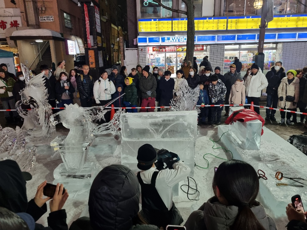 I have no idea what he was trying to carve but the crowd went silent as he took a deep breath and started stroking the chainsaw like a paint brush across the now rejoined ice slab. 
